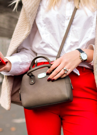 Mulher posando com bolsa marrom pequena
